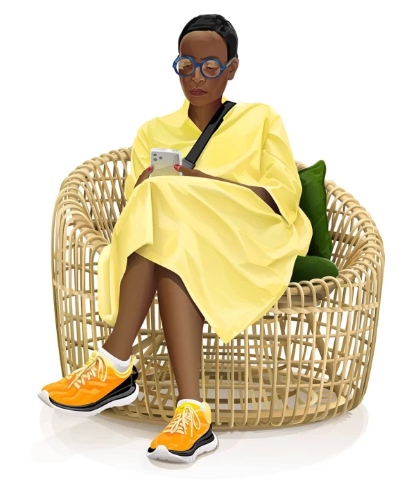 Image of a stylish Black woman sitting in a wicker chair, looking at her phone.